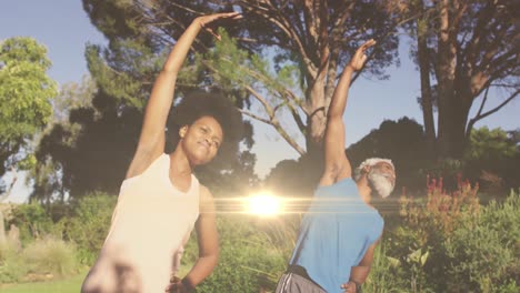 Animation-of-light-trails-over-african-american-couple-doing-yoga,-stretching,-slow-motion