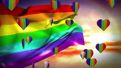 Animation-of-rainbow-hearts-and-flag-over-sky-with-clouds