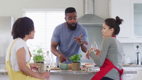 Diverse-male-and-female-friends-preparing-food-together-in-kitchen