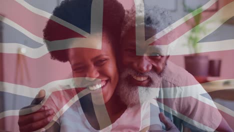 Animation-of-flag-of-uk-over-senior-african-american-father-and-adult-daughter
