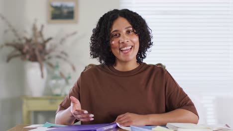 Biracial-woman-making-business-video-call-at-home,-talking-and-gesturing,-slow-motion