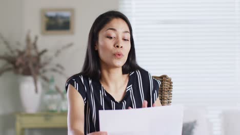 Asian-woman-making-business-video-call-at-home,-talking-and-gesturing,-slow-motion