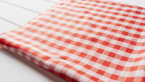 Close-up-of-folded-red-and-white-checkered-blanket-on-white-background-with-copy-space