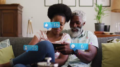 Animation-of-social-media-icons-and-networks-over-african-american-man-and-woman-with-tablet