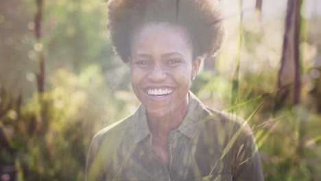 Animation-of-grass-over-african-american-woman-smiling