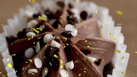 Animation-Von-Goldenem-Konfetti,-Das-Umfällt,-Nahaufnahme-Eines-Schokoladen-Cupcakes