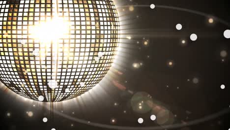 Animation-of-glowing-spots-of-light-over-shiny-golden-disco-ball-spinning-against-black-background