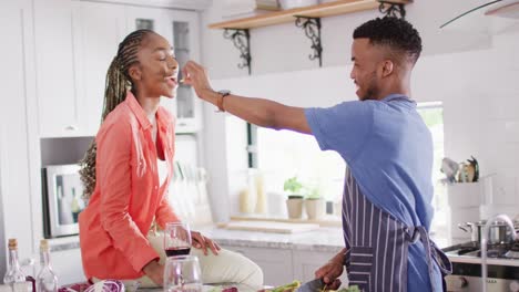Glückliches-Afroamerikanisches-Paar,-Das-In-Der-Küche-Essen-Zubereitet-Und-Gericht-Probiert