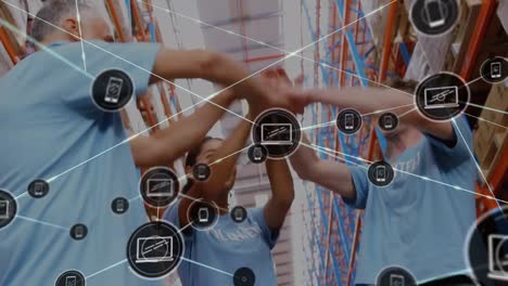 Animation-of-network-of-connections-with-icons-over-diverse-volunteers-hand-stacking-in-warehouse