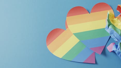 Video-of-rainbow-hearts-over-blue-background-with-copy-space