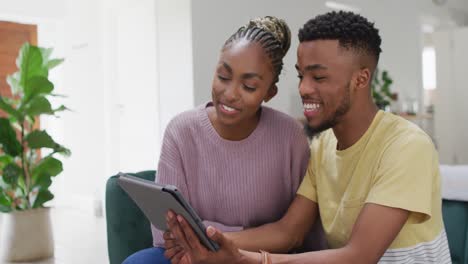 Glückliches-Afroamerikanisches-Paar,-Das-Während-Eines-Videoanrufs-Auf-Dem-Tablet-Mit-Der-Kamera-Spricht