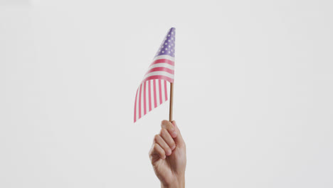 Nahaufnahme-Einer-Hand,-Die-Die-Nationalflagge-Der-USA-Auf-Weißem-Hintergrund-Mit-Kopierraum-Hält