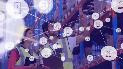 Animation-of-network-of-connections-with-icons-over-diverse-workers-at-warehouse