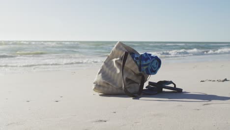 Video-Einer-Tasche-Mit-Strandausrüstung,-Die-Im-Sand-Am-Strand-Liegt