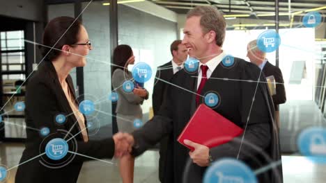 Animation-of-network-of-icons-over-caucasian-businessman-and-businesswoman-shaking-hands-at-office