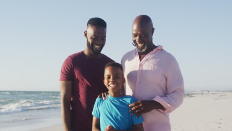 Video-Eines-älteren-Afroamerikanischen-Vaters-Und-Eines-Erwachsenen-Sohnes,-Die-Am-Strand-Spazieren-Gehen-Und-Reden