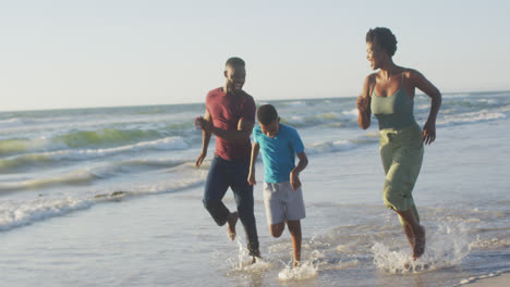 Video-Einer-Glücklichen-Afroamerikanischen-Familie,-Die-Spaß-Am-Strand-Hat