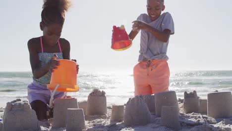 Video-Von-Glücklichen-Afroamerikanischen-Kindern,-Die-Am-Strand-Mit-Sand-Spielen