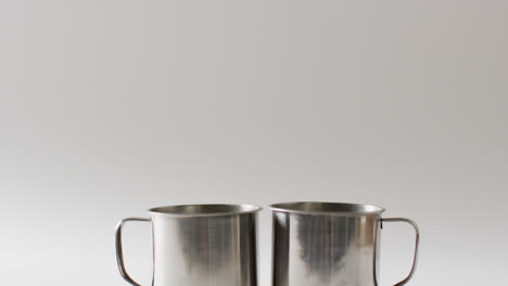 Two-metal-camping-mugs-and-copy-space-on-white-background