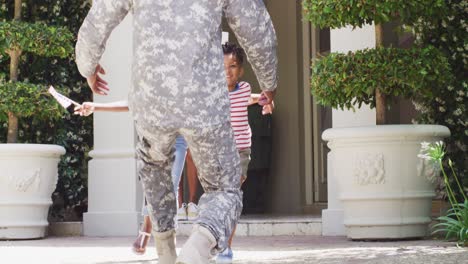 African-american-male-soldier-returning-home,-greeted-by-happy-son-and-daughter,-slow-motion