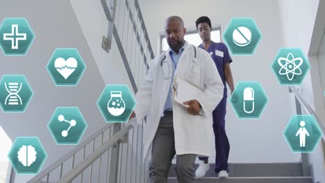 Animation-of-medical-icons-over-african-american-female-and-male-doctor-rushing-down-staircase