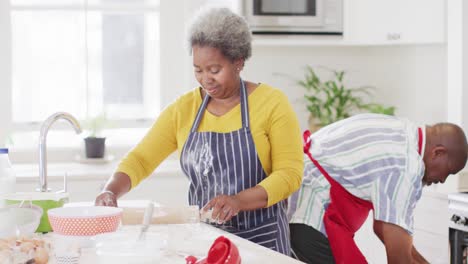 Fröhliches-Afroamerikanisches-Seniorenpaar,-Das-Gemeinsam-In-Der-Küche-Backt,-Zeitlupe
