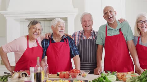 Portrait-of-happy-diverse-senior-male-and-female-friends-preparing-food-in-kitchen,-slow-motion