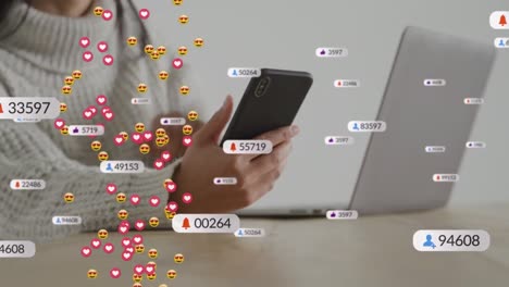 Animation-of-social-media-icons-and-face-emojis-against-mid-section-of-woman-using-smartphone