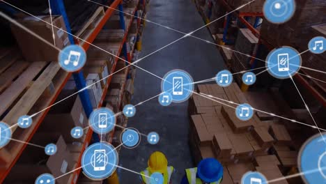 Animation-of-network-of-digital-icons-against-aerial-view-of-workers-working-at-warehouse