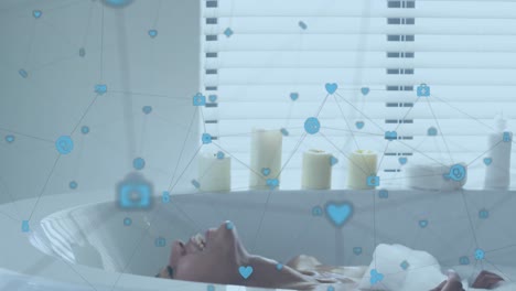 Animation-of-network-of-digital-icons-over-biracial-woman-relaxing-in-a-bathtub-in-bathroom