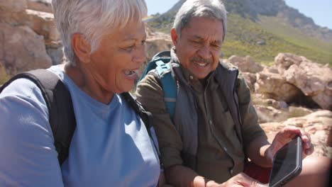 Happy-senior-biracial-couple-in-mountains-taking-selfie-with-smartphone,-in-slow-motion