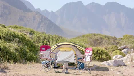 Landscape-of-beautiful-mountains-with-tent-and-chairs-on-sunny-day,-in-slow-motion