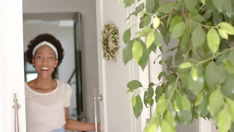 Retrato-De-Una-Feliz-Mujer-Afroamericana-Abriendo-La-Puerta,-En-Cámara-Lenta