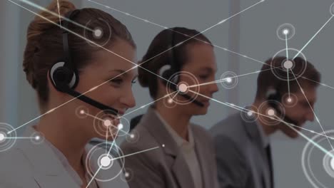 Animation-of-network-of-connections-over-caucasian-woman-talking-on-phone-headset-at-office