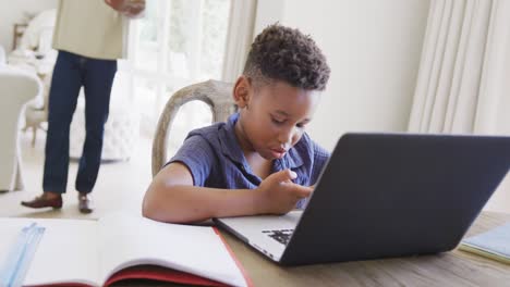 Happy-african-american-boy-using-laptop-for-online-lesson,-in-slow-motion