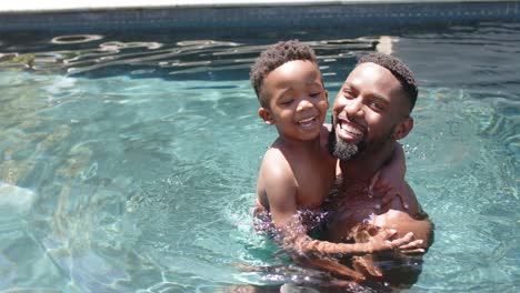 Porträt-Eines-Glücklichen-Afroamerikanischen-Vaters-Und-Sohnes,-Die-In-Zeitlupe-Am-Pool-Spielen