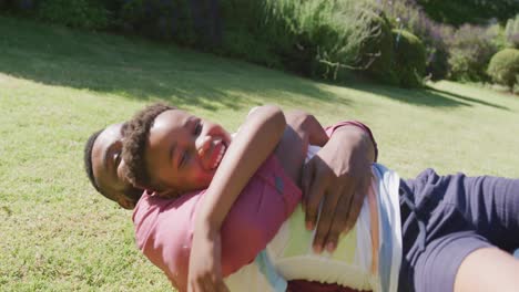 Happy-african-american-father-and-son-playing-in-garden,-in-slow-motion