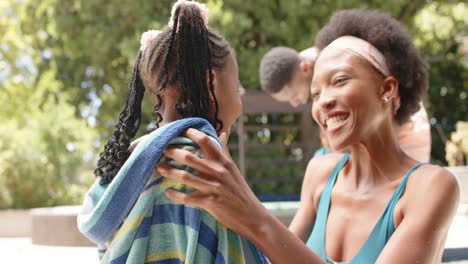 Happy-african-american-mother-toweling-her-daughter-at-pool,-in-slow-motion