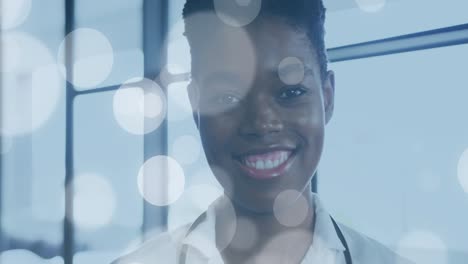 Animation-Von-Lichtflecken-über-Einer-Afroamerikanischen-Ärztin
