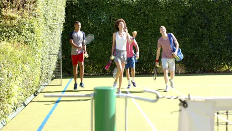 Fröhliche,-Vielfältige-Gruppe-Von-Freunden,-Die-Auf-Dem-Tennisplatz-Spazieren-Gehen-Und-Reden
