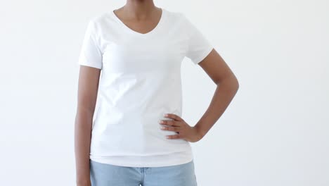 Midsection-of-african-american-woman-wearing-white-t-shirt-with-copy-space-on-white-background