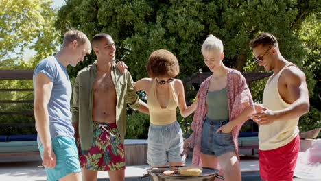 Happy-diverse-group-of-friends-having-bbq-at-pool-in-summer