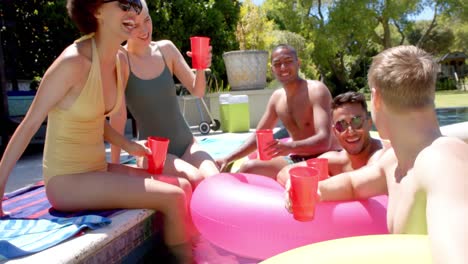 Happy-diverse-friends-drinking-drinks-at-pool-party-in-summer