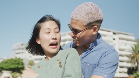Happy-biracial-couple-embracing-on-promenade,-in-slow-motion