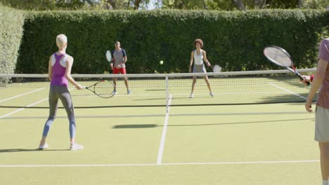 Fröhliche,-Vielfältige-Gruppe-Von-Freunden,-Die-Auf-Dem-Tennisplatz-Tennis-Spielen