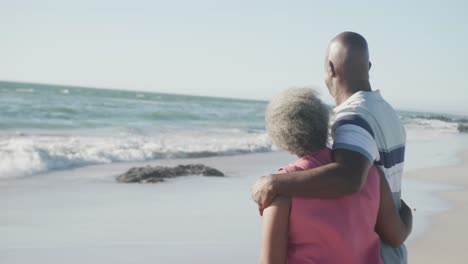 Happy-senior-african-american-couple-embracing-at-beach-with-copy-space,-in-slow-motion