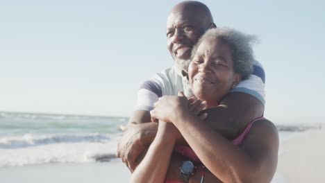 Glückliches-älteres-Afroamerikanisches-Paar,-Das-Sich-Am-Strand-Umarmt,-In-Zeitlupe