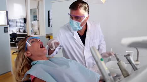 Dentista-Pediátrico-Hablando-Y-Examinando-Los-Dientes-De-Un-Paciente