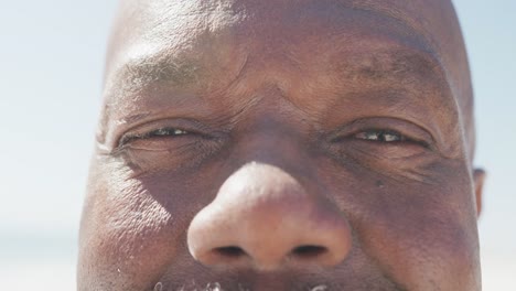 Portrait-of-happy-senior-african-american-man-smiling-at-beach,-in-slow-motion