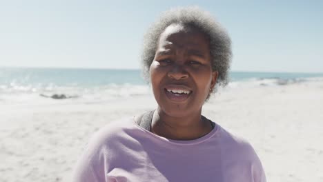 Portrait-of-happy-senior-african-american-woman-smiling-at-beach,-in-slow-motion